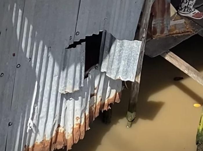 Lỗ trống trên vách căn nhà sàn của gia đình bà K. là điểm nghi ngờ bé trai bị lọt xuống sông mất tích